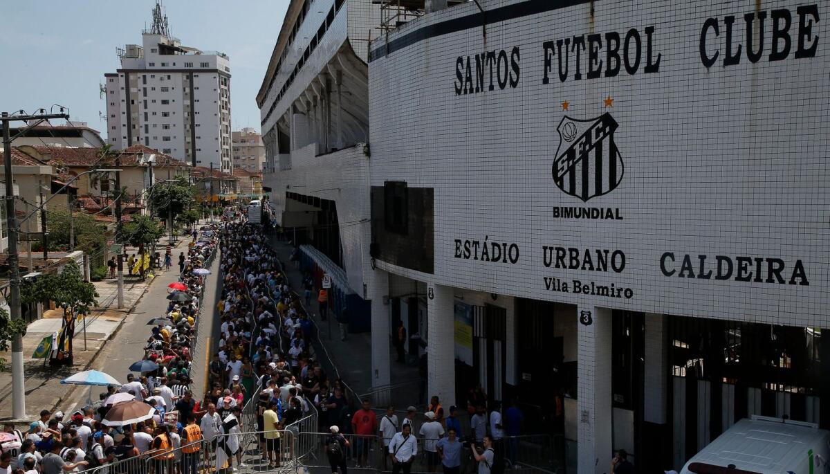 Fans gather outside the Urbano Caldeira stadium to attend Pele's wake. — AFP