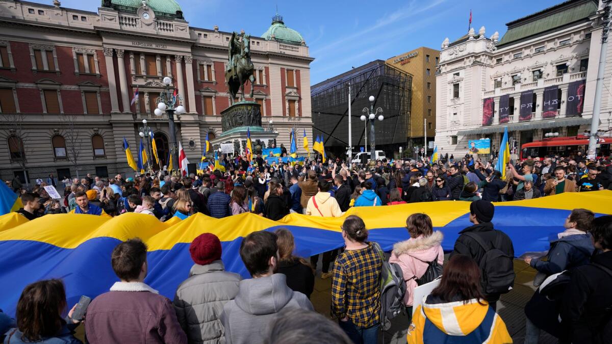 People hold a giant Ukrainian flag during a rally to mark the one-year anniversary of Russia's invasion of Ukraine in Belgrade on Friday. - AP
