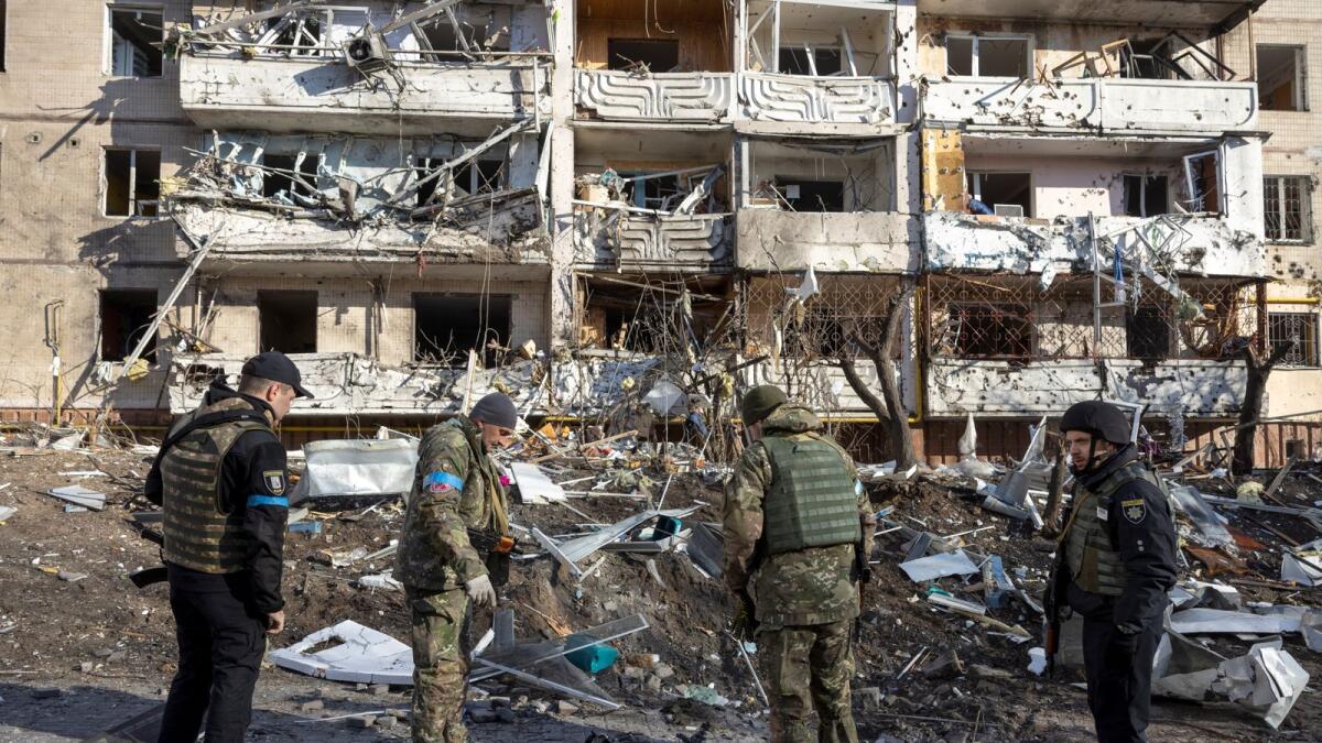 Ukraine soldiers inspect the rubble of a destroyed apartment building in Kyiv on March 15, 2022, after strikes on residential areas killed at least two people, Ukraine emergency services said as Russian troops intensified their attacks on the Ukrainian capital. Photo: AFP