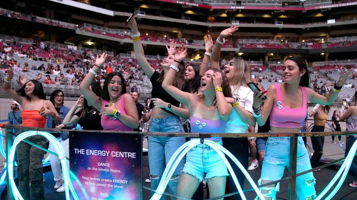 Concertgoers dance during Coldplay's Music of the Spheres world tour