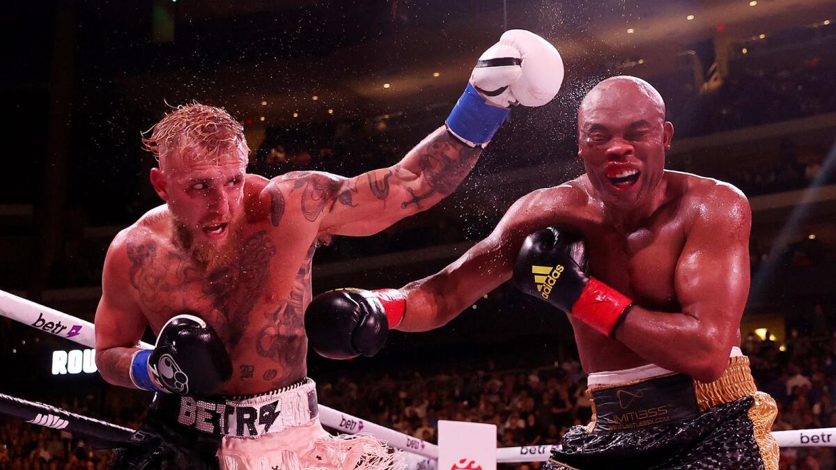 Jake Paul (L) exchanges strikes with Anderson Silva of Brazil during their cruiserweight bout at Desert Diamond Arena on October 29, 2022 in Glendale, Arizona.
