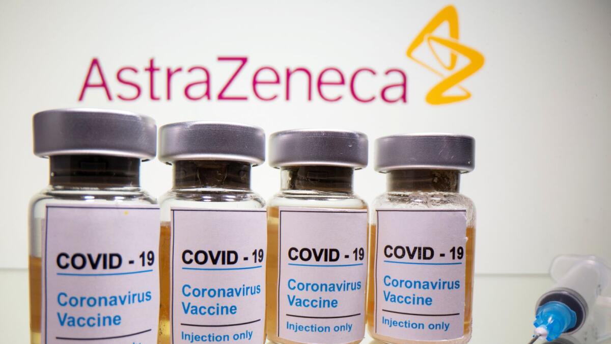 FILE PHOTO: Vials with a sticker reading, 'COVID-19 / Coronavirus vaccine / Injection only' and a medical syringe are seen in front of a displayed AstraZeneca logo in this illustration taken October 31, 2020. REUTERS/Dado Ruvic/Illustration/File Photo