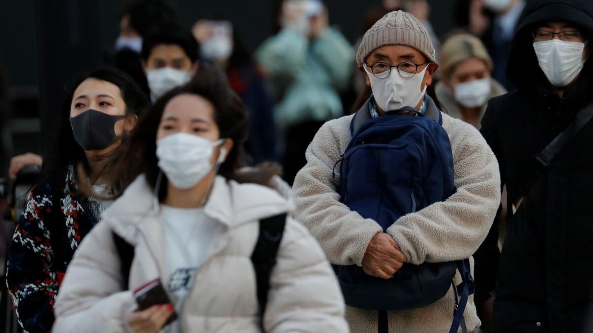 Pedestrians, wearing protective masks against Covid-19, make their way in Tokyo, Japan. (Photo: Reuters)