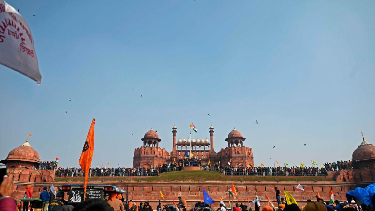 Farmers stand on the ramparts of Red Fort as they continue to protest against the central government's recent agricultural reforms in New Delhi on January 26, 2021. AFP