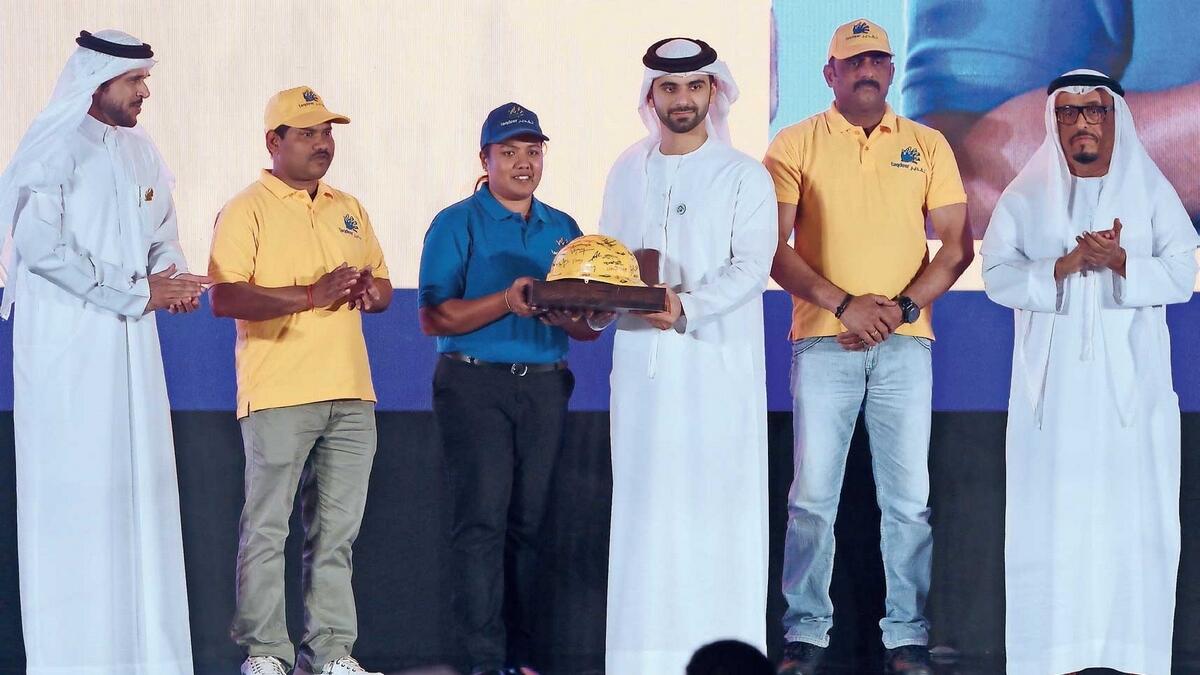 Labourers present a gift as a gesture of thanks to Sheikh Mansour during the Taqdeer Award ceremony in Dubai on Monday as other senior officials look on.  — Photo by Juidin Bernarrd
