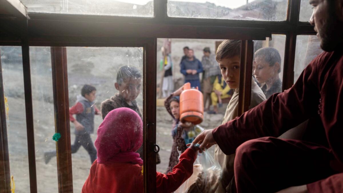 Afghan children buy bread from a bakery in Kabul. — AP