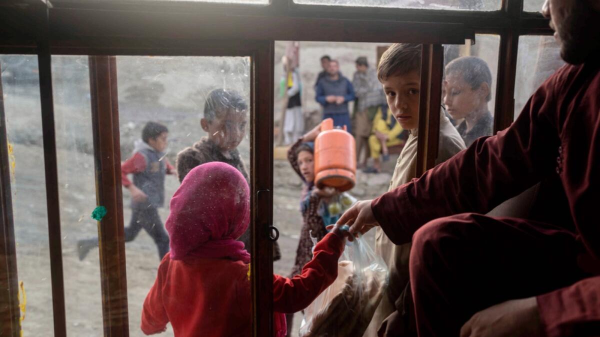 Afghan children buy bread from a bakery in Kabul. — AP