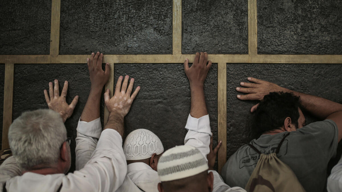 In this Monday, Sept. 21, 2015 photo, Muslim pilgrims pray while touching the Kaaba, the cubic building at the Grand Mosque in the Muslim holy city of Mecca, while performing Tawaf, an anti-clockwise movement around the Kaaba and one of the main rites of the annual pilgrimage, known as hajj, in Saudi Arabia. (AP Photo/Mosa'ab Elshamy)