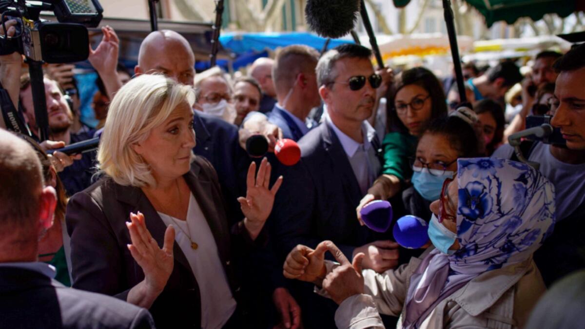 French far-right leader Marine Le Pen talks to a woman as she campaigns in a market in Pertuis. — AP