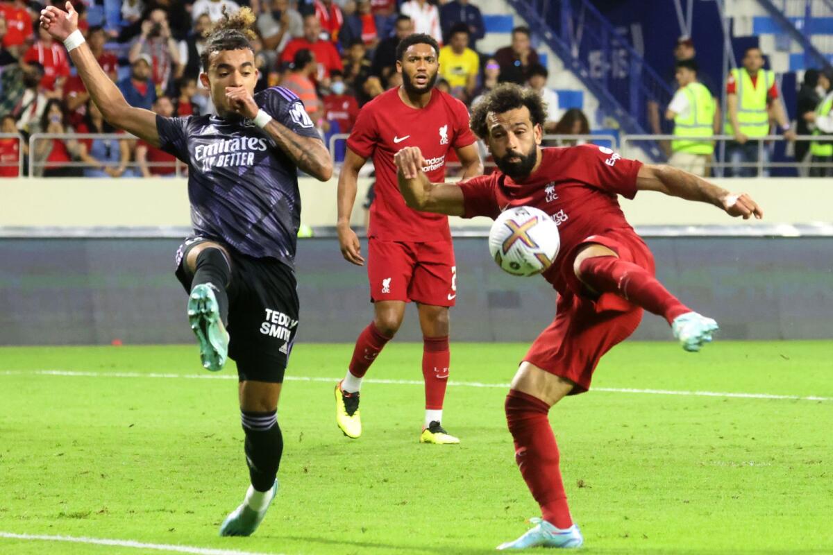 Lyon defender Malo Gusto (left) attempts to block a kick from Liverpool's Mohamed Salah. — AFP