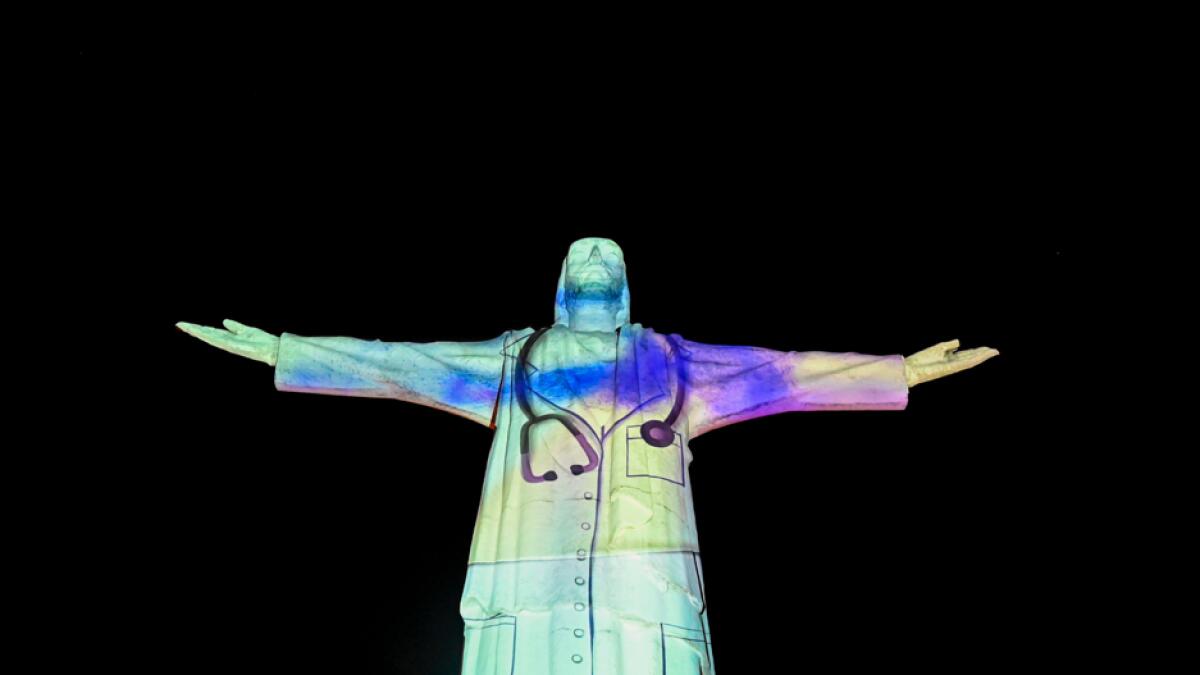 The image of a doctor is projected on the statue of Cristo Rey monument in Cali, Colombia, during celebrations for the 484th anniversary of the city, on July 25, 2020, amid the coronavirus pandemic. The projection was held to send a message of hope in the midst of the pandemic and to thank the staff who are fighting on the front line against Covid-19. Photo: AFP