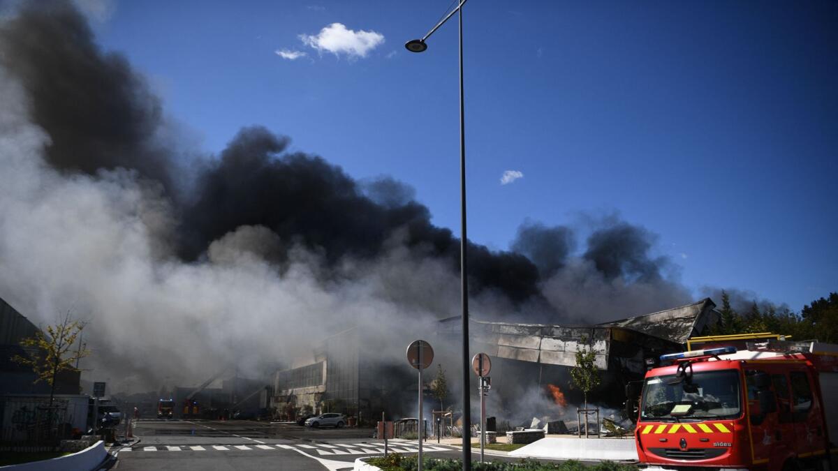 Black smoke billows into the sky as firefighters work to put out a fire a 'Rungis International Market. –AFP