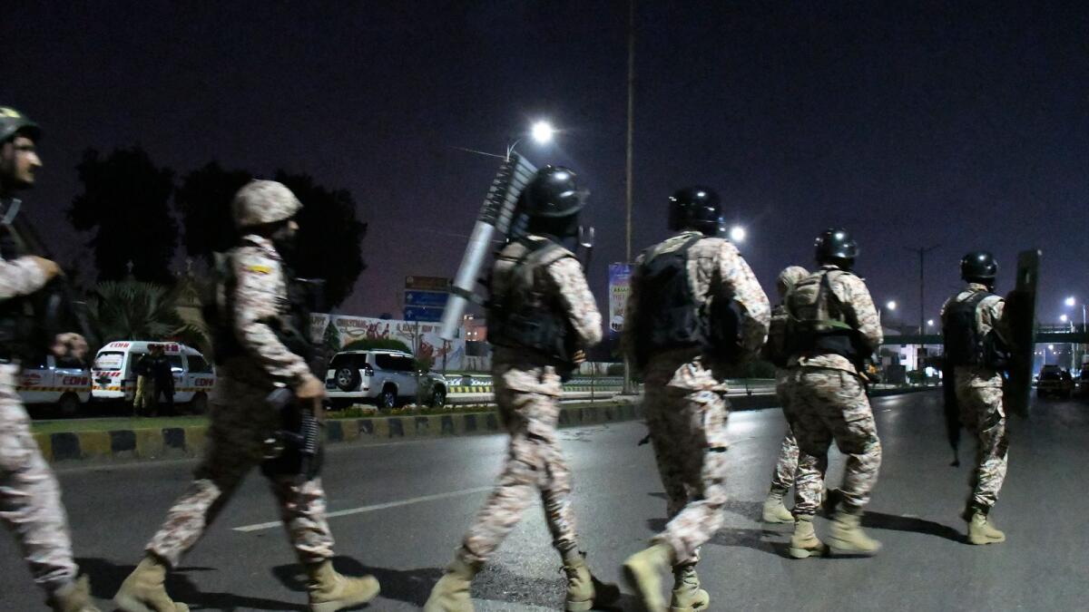 Paramilitary soldiers arrive at the incident site following gunmen attack on police headquarters, in Karachi, Pakistan, on Friday. — AP