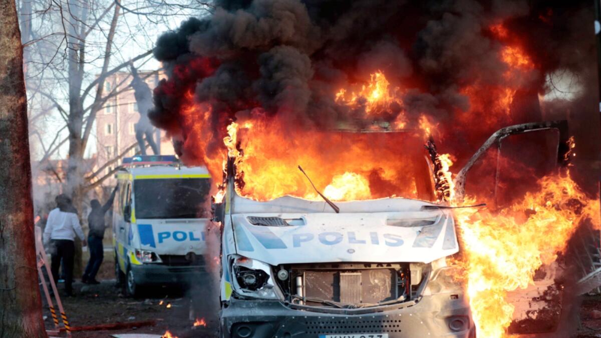Protesters set fire to a police bus in the park Sveaparken in Orebro, Sweden. — AP