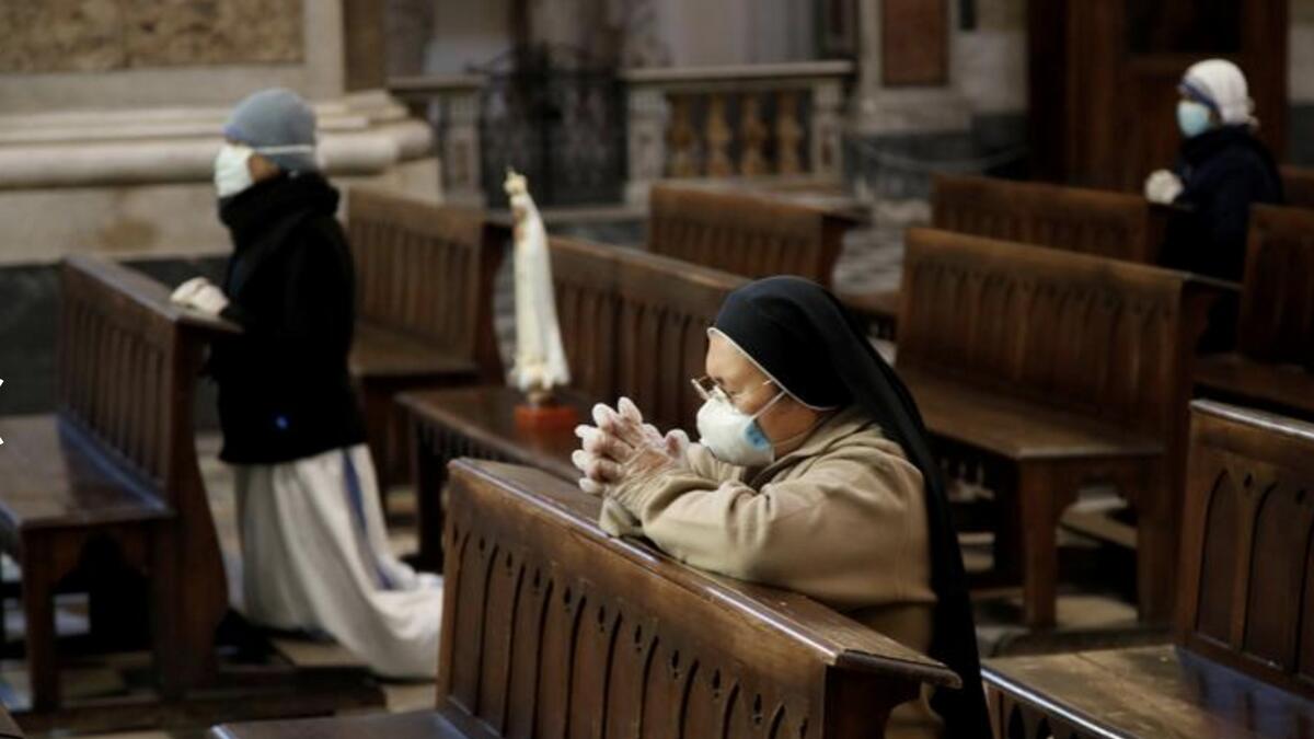 Nuns wearing protective masks and gloves pray during Easter Sunday Mass at Duomo di Napoli Cathedral, in Naples, Italy. Photo: Reuters