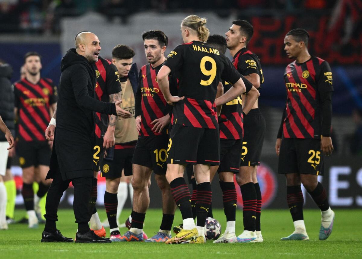 Manchester City manager Pep Guardiola talks to his players after the match. — Reuters