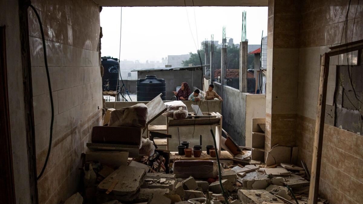 Palestinians check destruction after an Israeli strike in Rafah. — AP