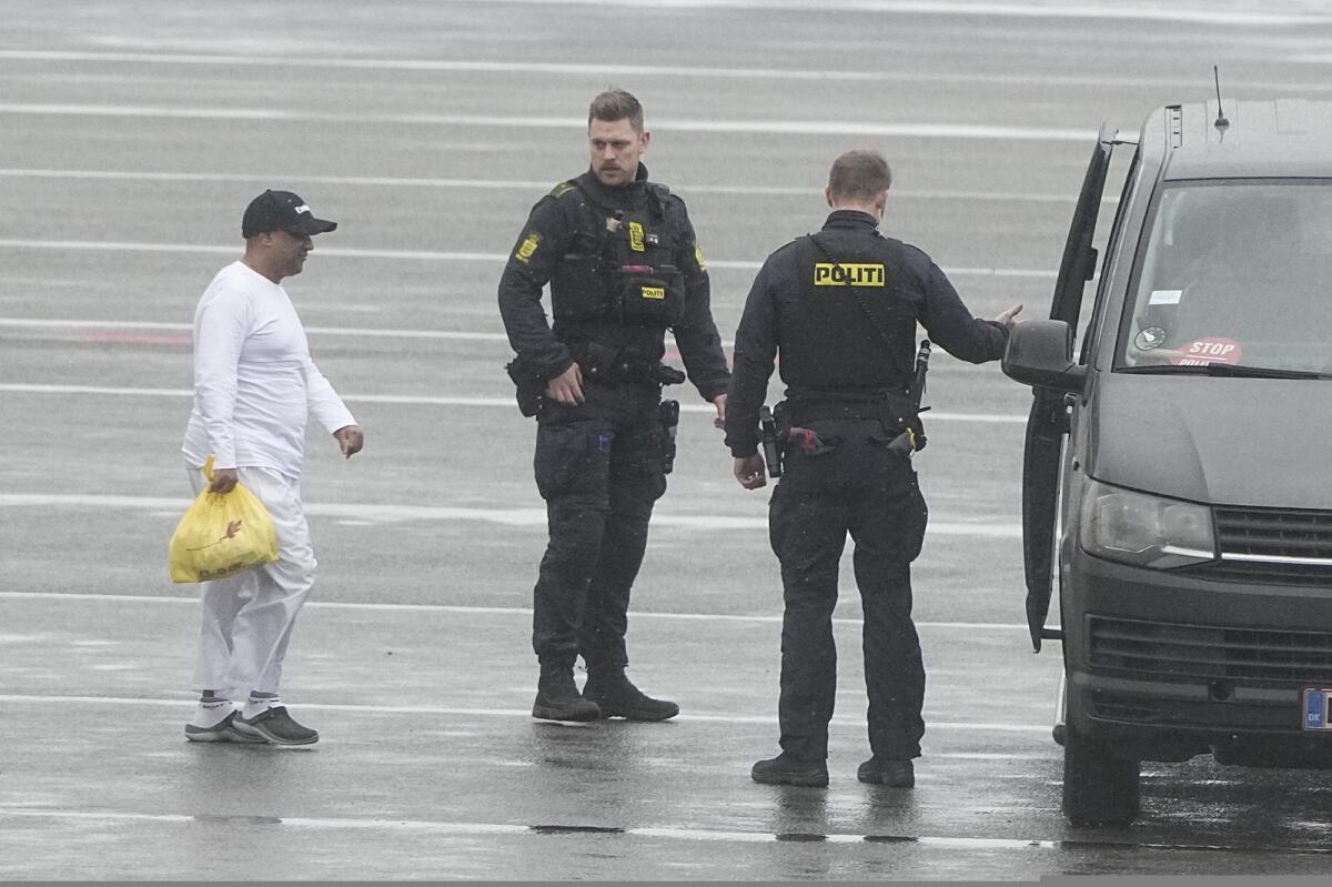 Danish police officers accompany financier Sanjay Shah as he arrives at Kastrup Airport. Photo: AP