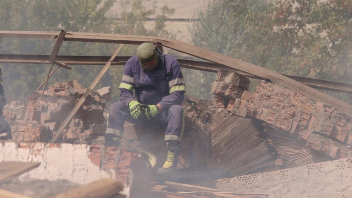 A Ukrainian firefighter takes rest in a factory destroyed by a Russian strike in the city of Slovyansk. — Reuters