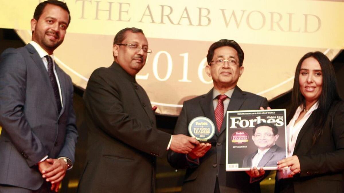 Joy Alukkas, chairman and MD of Joyalukkas Group, receives the 'Top Indian Business leader in the Arab region' award in Dubai on Tuesday. Also seen is T.P. Seetharam, Indian Ambassador to the UAE, and senior Forbes executives.