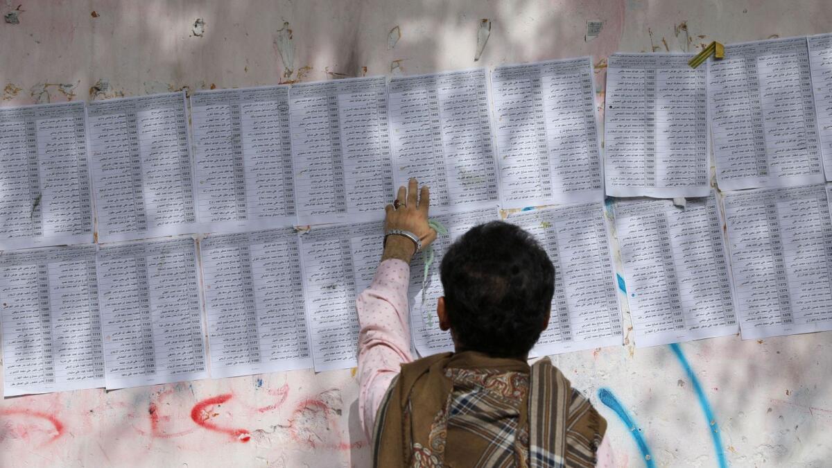 A man checks list of beneficiaries of food aid outside an aid distribution centre in Sanaa, Yemen. — Reuters file
