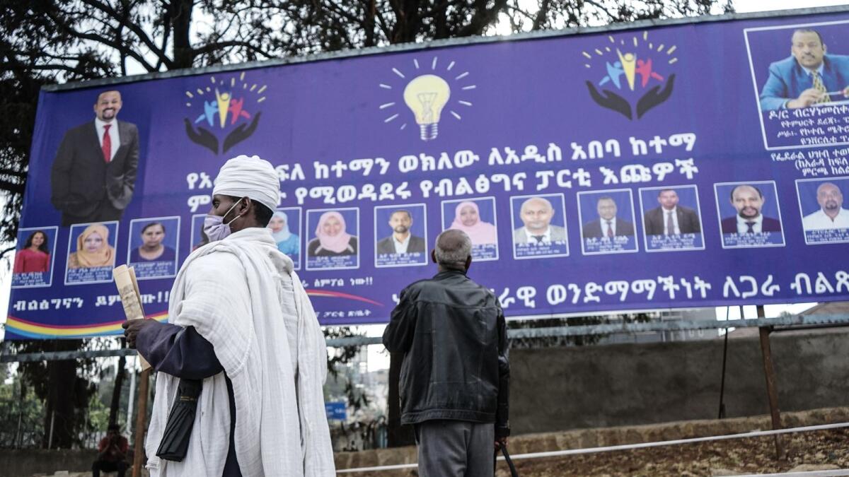 A man looks at a billboard of the political party of Ethiopian Prime Minister Abiy Ahmed,in Addis Ababa, Ethiopia. Photo: AFP