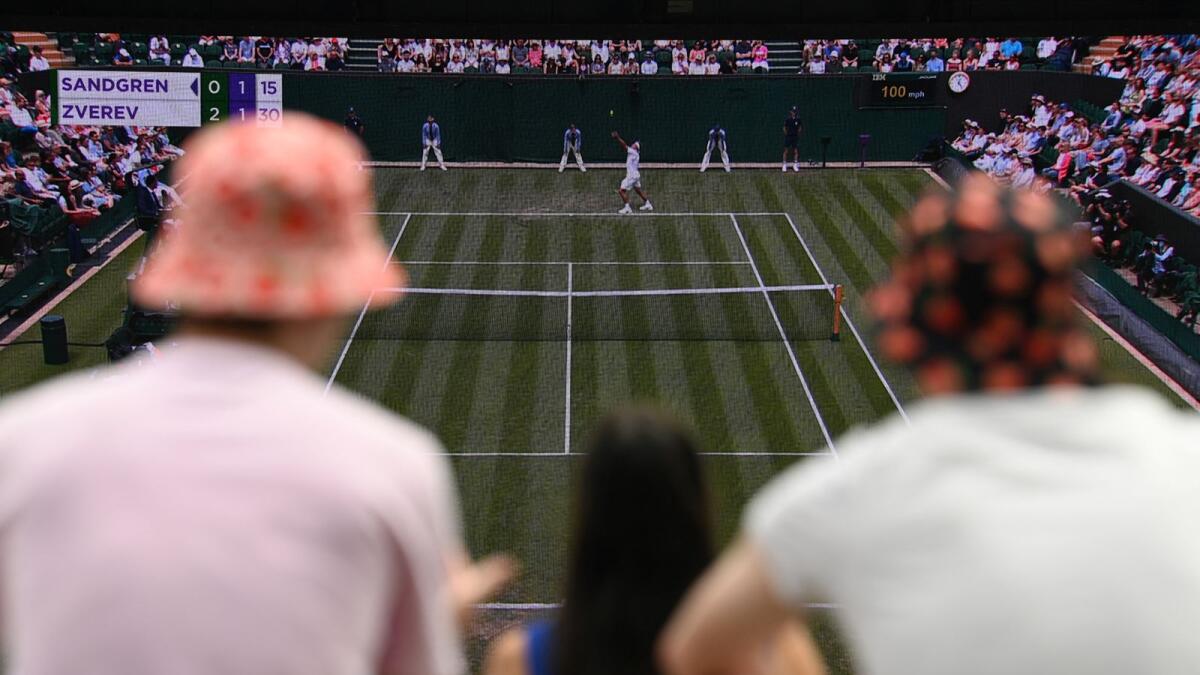People watch a match on a giant screen on the fourth day of the 2021 Wimbledon Championships. (AFP)