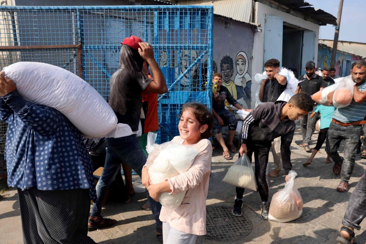 Palestinians rush to UN-run aid supply centre that distributes food to displaced families. Photo: AFP