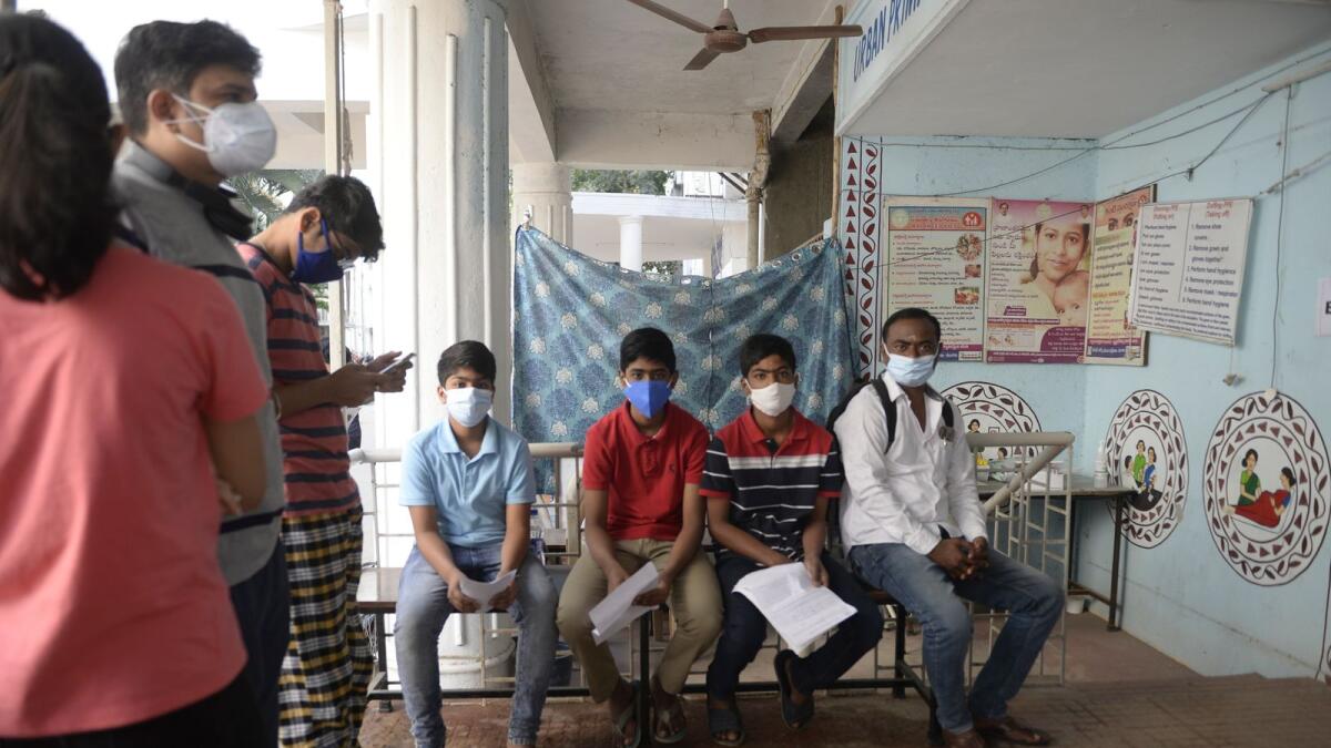Youths wait for their turn to get inoculated with a dose of a Covid-19 coronavirus vaccine during a vaccination drive for people in the 15-18 age group, at a primary health centre in Hyderabad on January 3, 2022. (Photo: AFP)