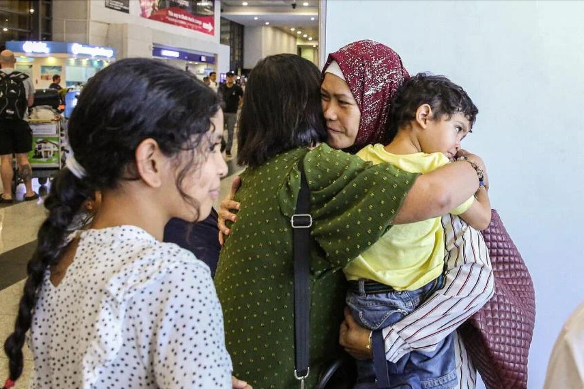 A Filipino national who crossed from the Gaza Strip into Egypt embracing her family members upon her arrival at Ninoy Aquino International Airport in Metro Manila on Nov 10, 2023. — AFP file