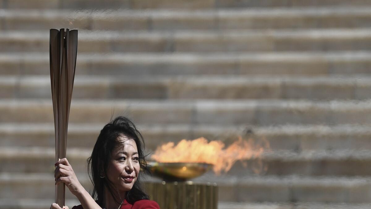 Former Japanese swimmer Imoto Naoko holds the Olympic torch during the Olympic flame handover ceremony for the 2020 Tokyo Summer Olympics, in Athens (AP)