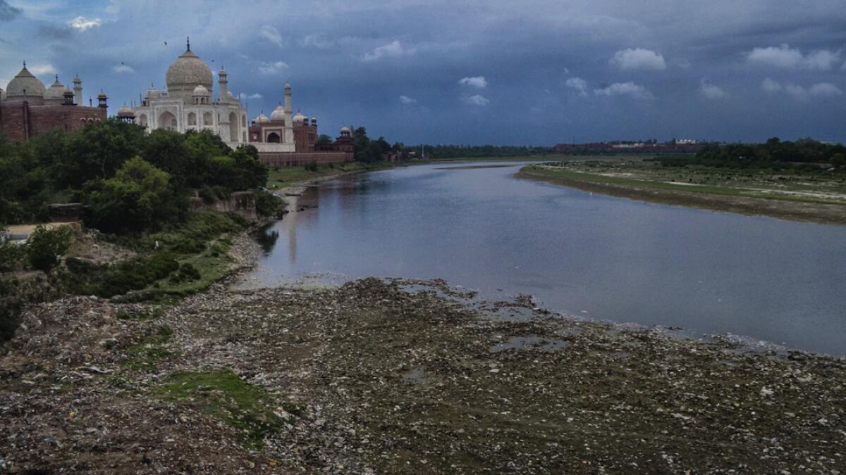 Yamuna river flows beside the historic Taj Mahal, in Agra. The water quality of the river, which had improved during lockdown, is deteriorating now due to various factors including rain washed garbage from drains emptying into the river. Photo: PTI