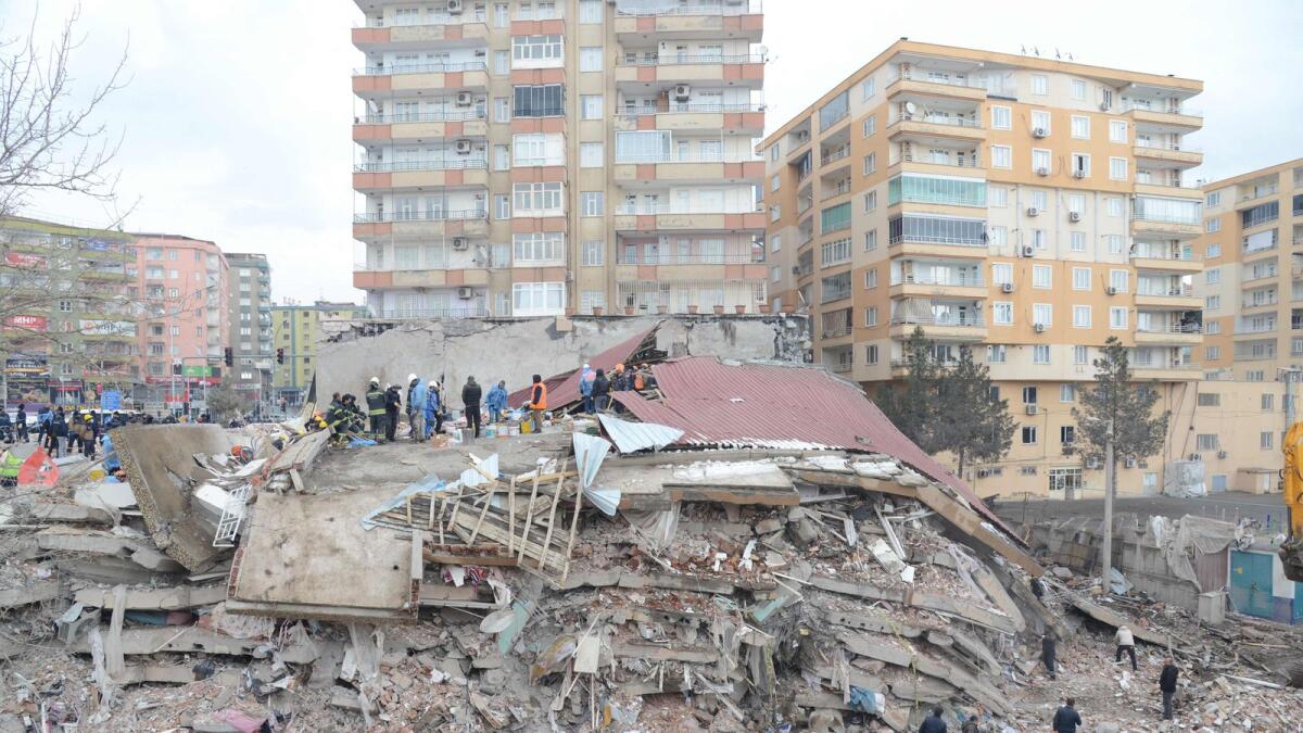 Rescue workers and volunteers conduct search and rescue operations in the rubble of a collasped building in Diyarbakir on February 6, 2023, after a 7.8-magnitude earthquake struck the country's south-east. — AFP