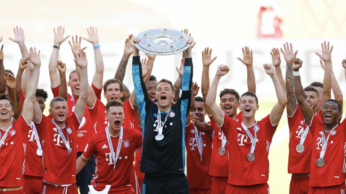 Munich's team captain manuel Neuer lifts the trophy after  the German Bundesliga soccer match between VfL Wolfsburg and FC Bayern Munich in Wolfsburg, German. Bayern wins the 8th straight Bundesliga title.  Photo: AP