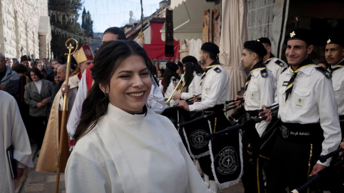 Sally Ibrahim Azar reacts to a scout band at a procession before she is ordained as the first female pastor in the Holy Land in the Old City of Jerusalem, on Sunday. — AP