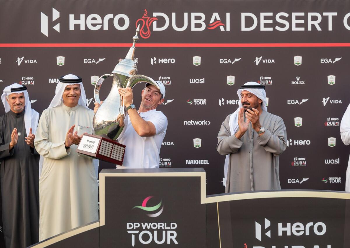 Sheikh Ahmed bin Saeed Al Maktoum, CEO and founder of Emirates Group, applauds as Rory McIlroy lifts the trophy after winning the Hero Dubai Desert Classic. — Photo by Shihab