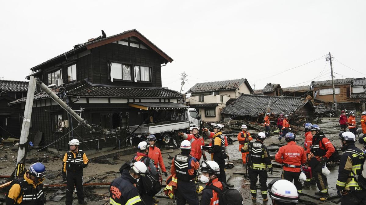 Firefighters and police search coastal area hit by earthquakes in Suzu. — AP