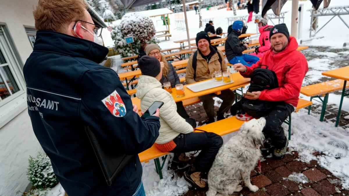 An official checks Covid-19 vaccination certificates of skiiers at Winterberg, Germany. – AP