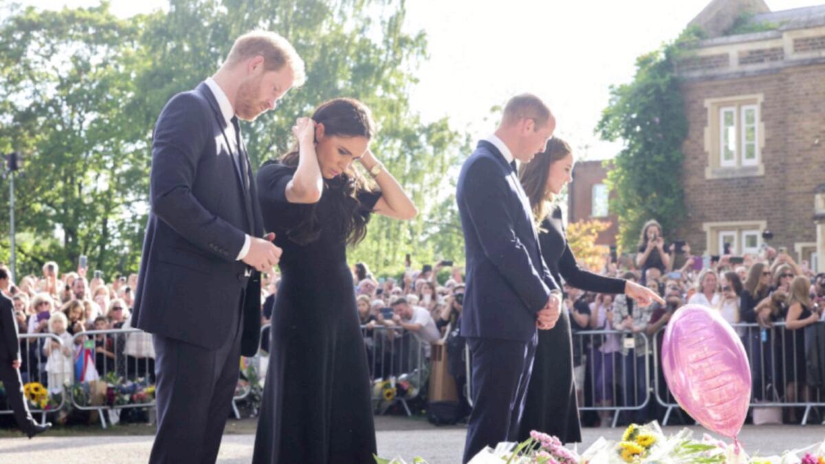 Prince Harry and his wife Meghan join Prince William and wife Kate to look at the tributes and flowers left outside Windsor Castle. — Reuters