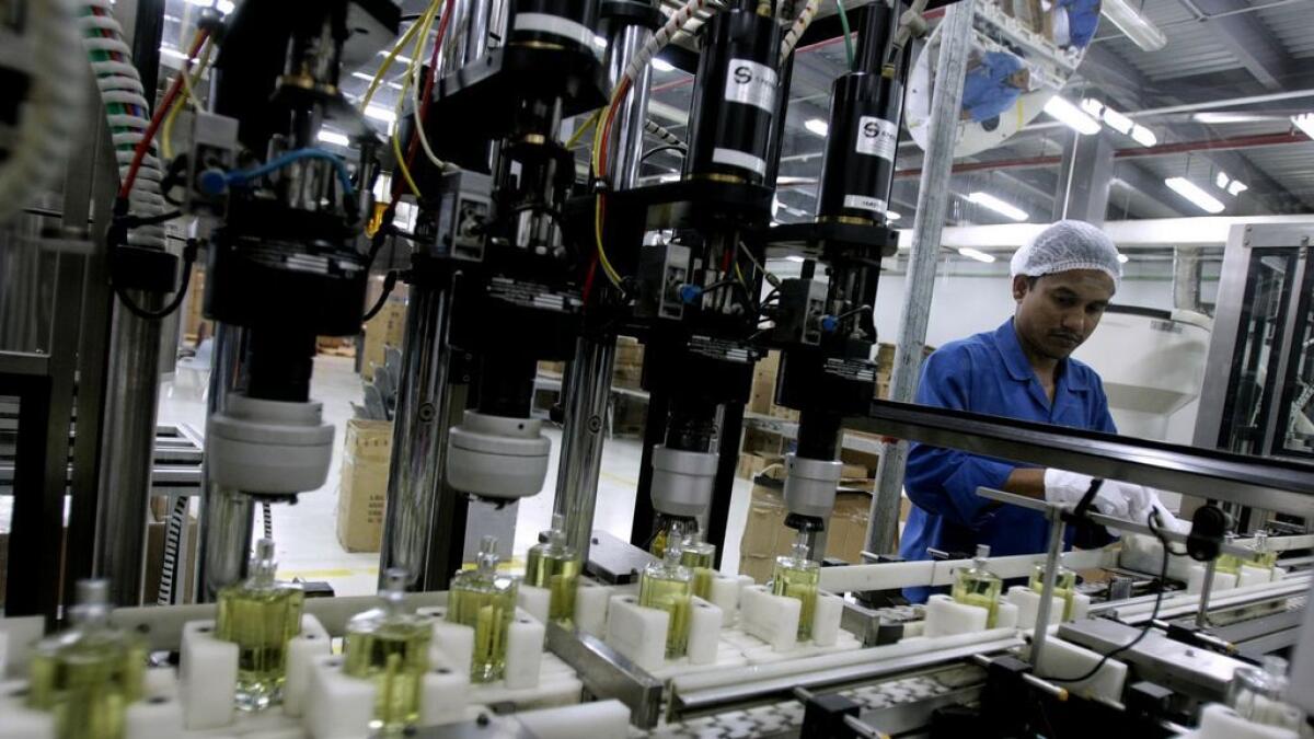 A worker bottles perfumes at a factory in Dubai. A considerable uplift in new business intakes supported a robust increase in activity across the non-oil sector in October. — File photo