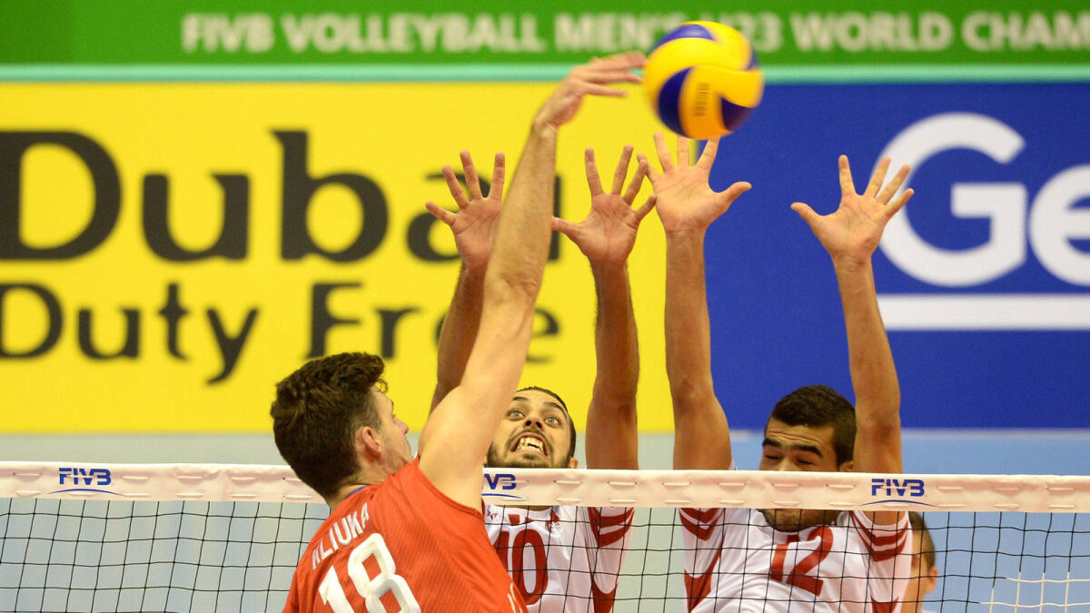 Russia’s Egor Kliuka attacks against Tunisia’s Elyes Garfi and Mohamed Brahem during their Men’s Under-23 Volleyball Championship match. 