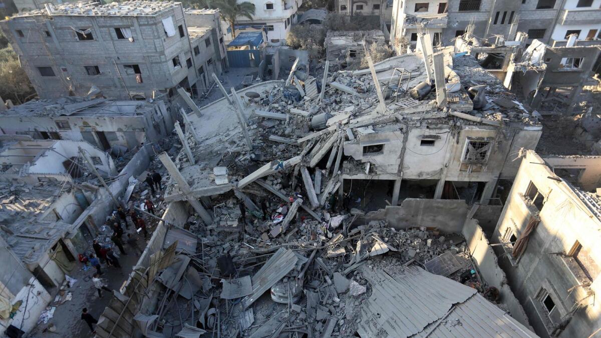 Palestinians inspect the damage following Israeli strikes on the Zawayda area of the central Gaza Strip on December 30. — AFP