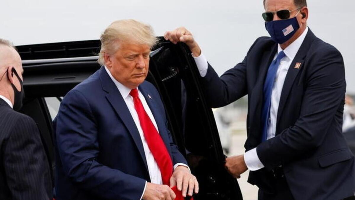 Trump holds a 'Make America Great Again' cap while arriving to board Air Force One as he departs Florida for campaign travel to North Carolina on November 2, 2020. Reuters