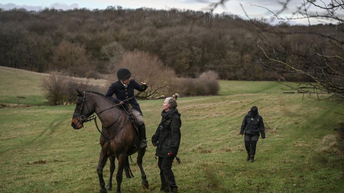 A member of the Warwickshire Hunt records a video with her smartphone of anti-hunting activists whom she accused of trespassing, in Warwickshire County, England, on January 14, 2023. Mary Turner/The New York Times)