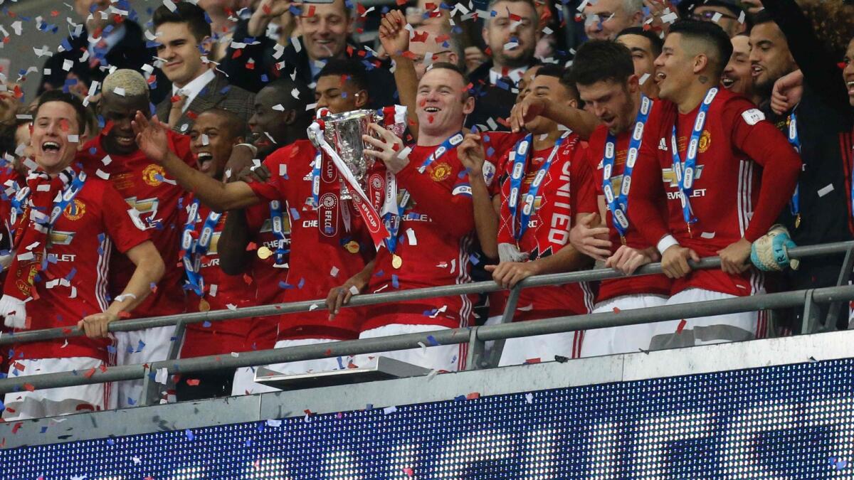 Manchester United's Wayne Rooney lifts the trophy as Manchester United players celebrate their victory after the English League Cup final in 2017. The club hasn't won a trophy after 2017. — AFP file