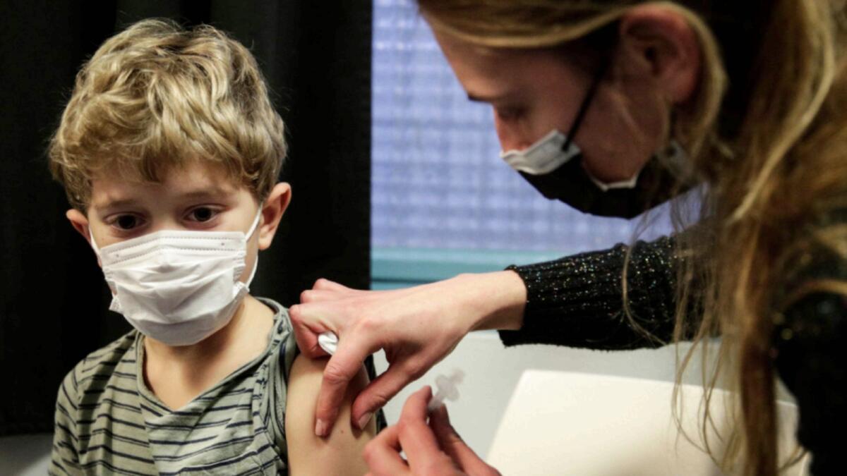 A child receives a dose of the Pfizer/BioNTech vaccine against Covid-19 in Paris. — AFP
