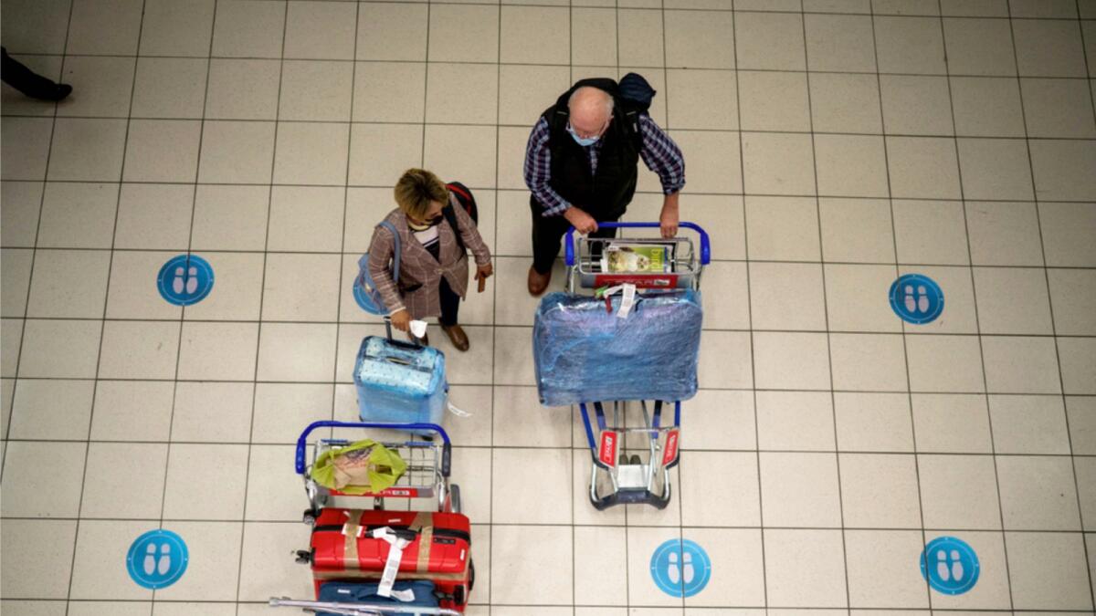 Passengers wait at OR Tambo's airport in Johannesburg, South Africa on Friday. — AP