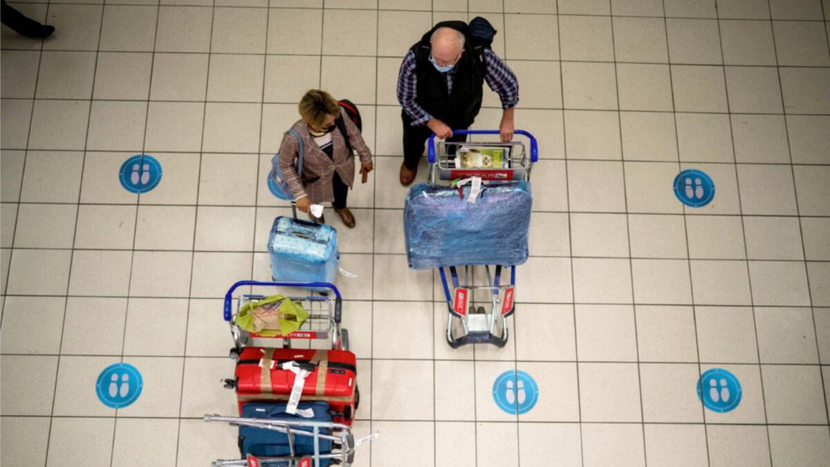 Passengers wait at OR Tambo's airport in Johannesburg, South Africa on Friday. — AP