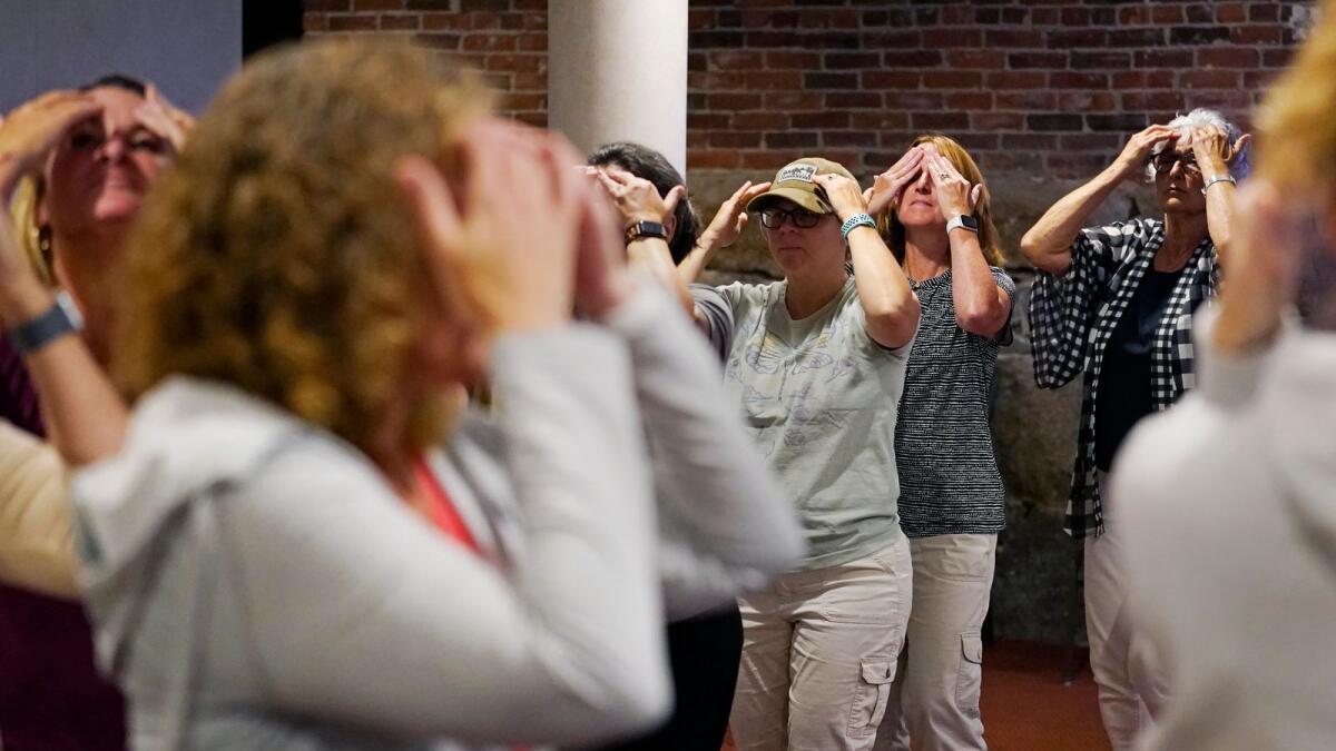Teachers follow each other in a circle during a workshop helping teachers find a balance in their curriculum while coping with stress and burnout in the classroom in Concord, New Hampshire. — AP file