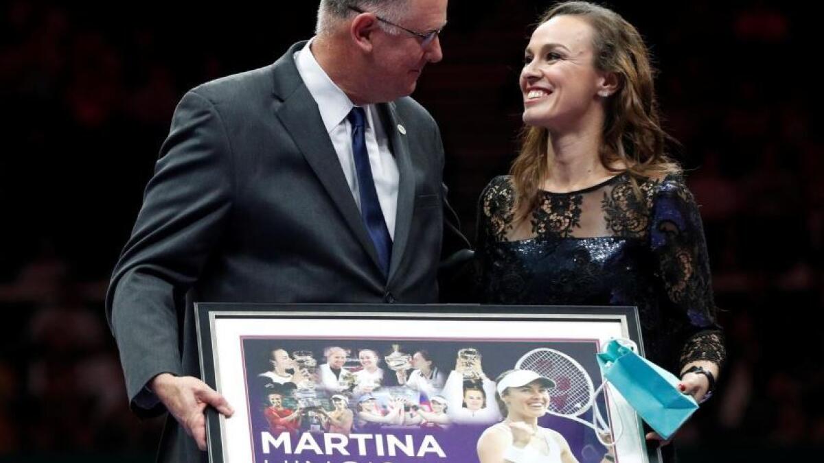Switzerland's Martina Hingis is presented with gifts from WTA CEO Steve Simon. (Reuters file)